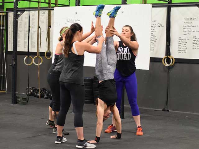 Group of ladies practicing handstands