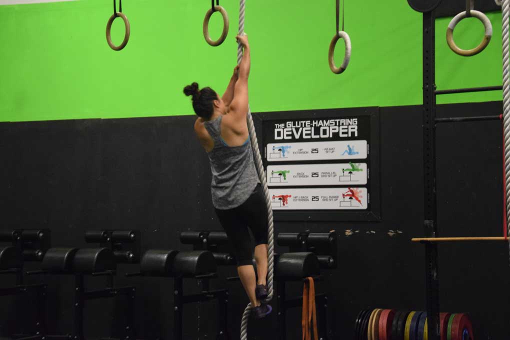 Back of woman doing a rope climb